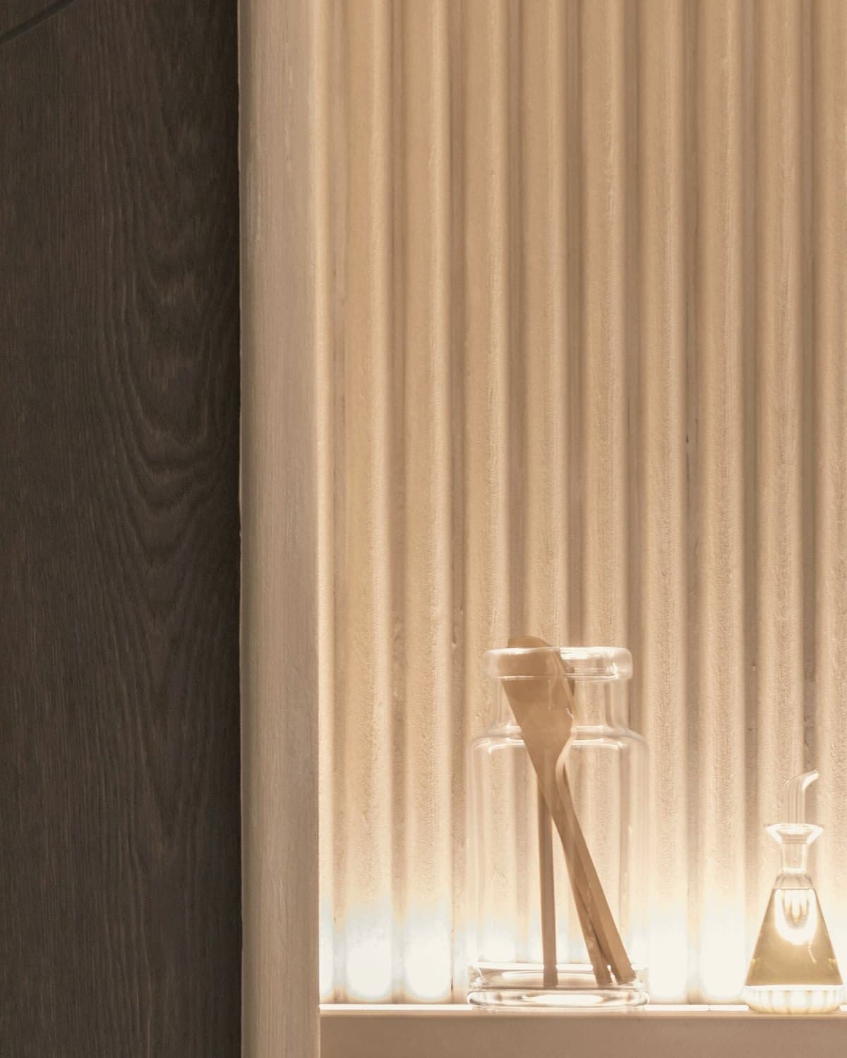 Nicho de travertino canelado com iluminação embutida — referência conceitual